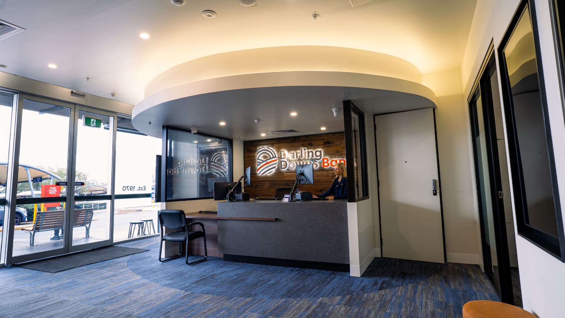 Completed commercial reception area with custom desk, glazing and curved ceiling detail